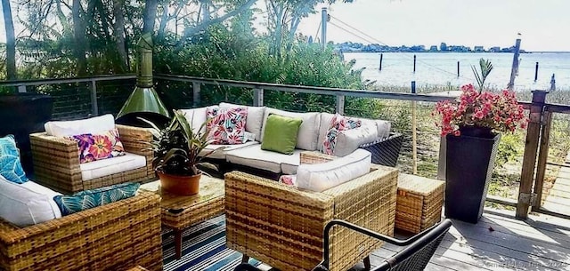 balcony featuring a water view and an outdoor living space