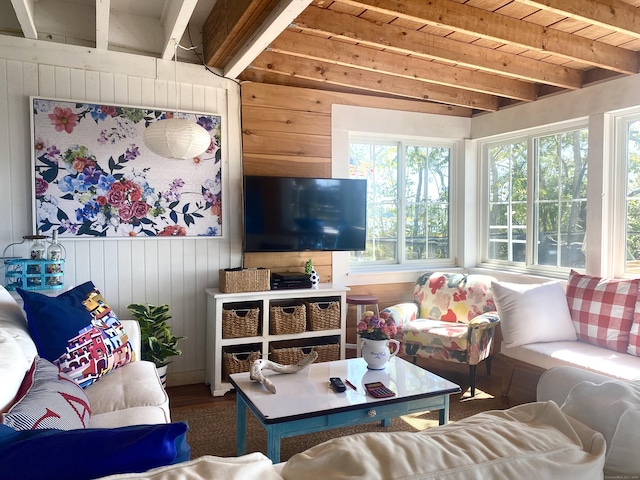living area featuring wood walls, beam ceiling, and wood finished floors
