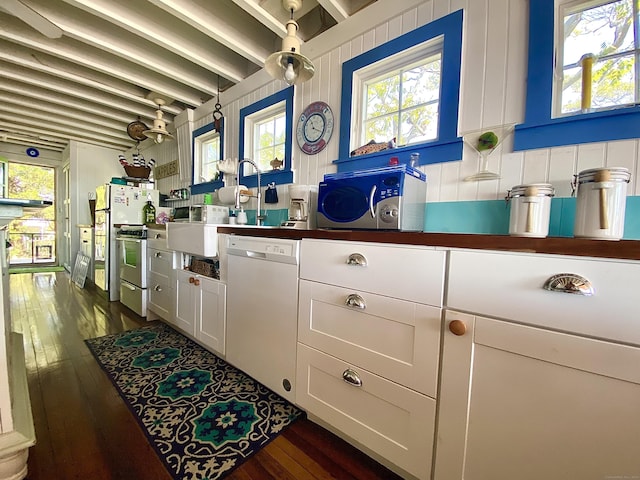 interior space with dark countertops, a wealth of natural light, and white appliances