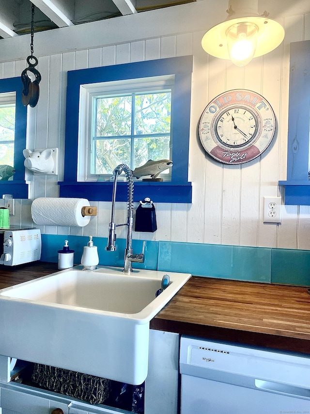 kitchen featuring a sink, wood counters, plenty of natural light, and dishwasher