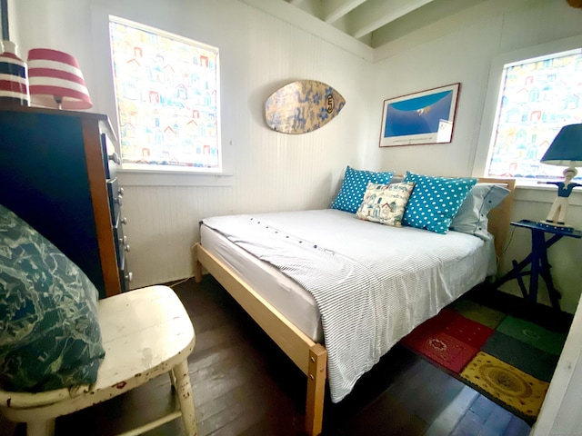 bedroom with multiple windows and wood finished floors
