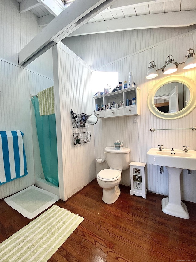 bathroom with a stall shower, toilet, and wood finished floors