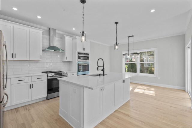 93 Wyoming St, Stratford, CT 06614 - kitchen featuring stainless steel appliances, wall chimney exhaust hood, a sink, crown molding, and light wood-style floors