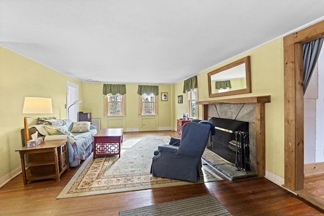 living room with a premium fireplace, baseboards, and hardwood / wood-style floors
