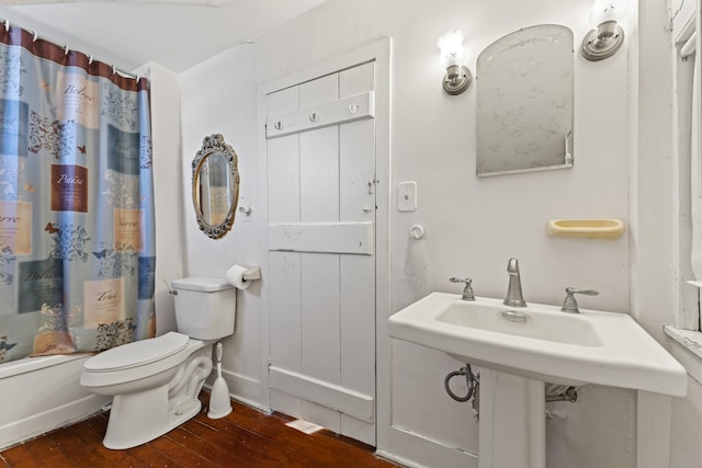 full bathroom featuring baseboards, toilet, hardwood / wood-style floors, and shower / tub combo with curtain
