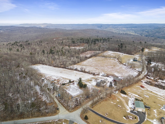 aerial view with a wooded view and a mountain view