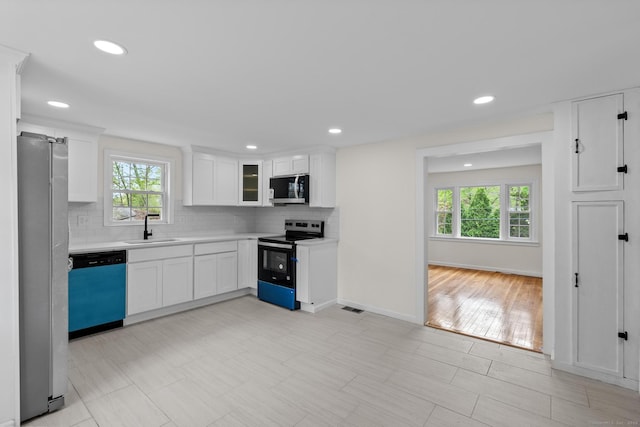 kitchen featuring light countertops, appliances with stainless steel finishes, plenty of natural light, and a sink