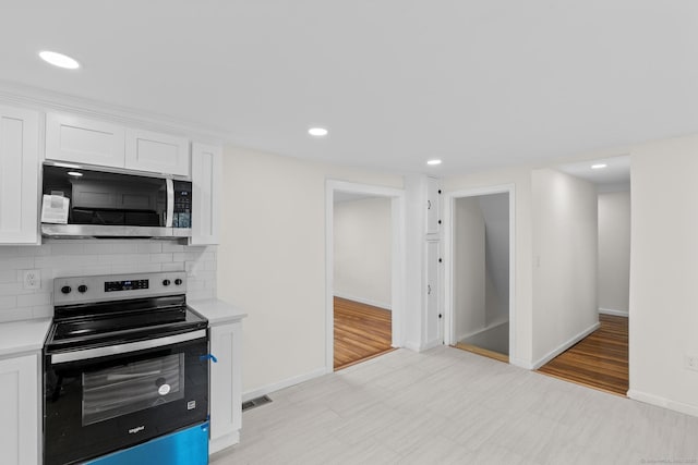 kitchen with light countertops, appliances with stainless steel finishes, recessed lighting, and white cabinetry