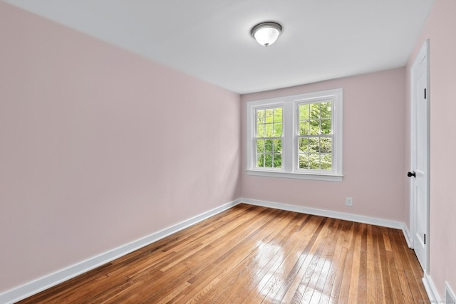 spare room featuring baseboards, visible vents, and light wood-type flooring