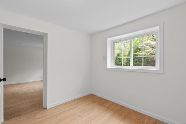 empty room with baseboards and light wood finished floors
