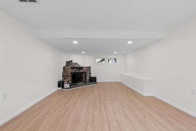 unfurnished living room featuring recessed lighting, baseboards, wood finished floors, and a fireplace