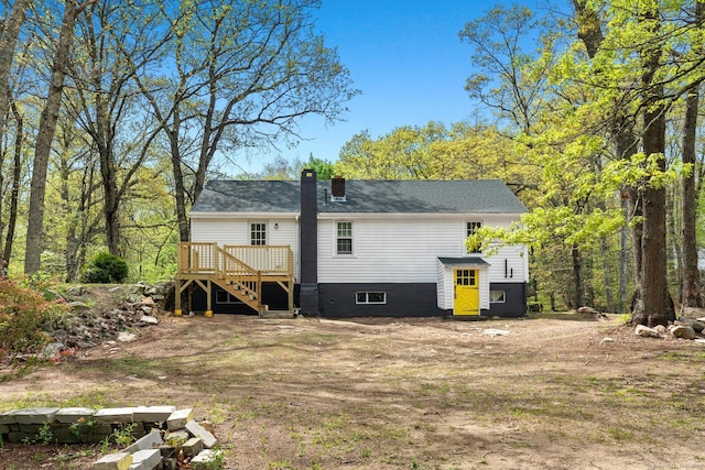 rear view of house with a deck, a chimney, and stairs