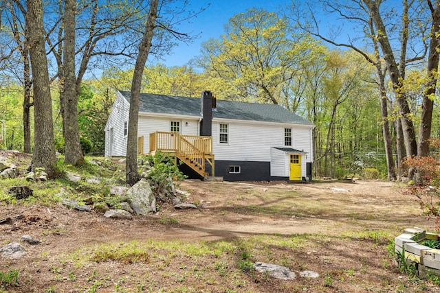 view of home's exterior featuring a deck, a chimney, and stairs