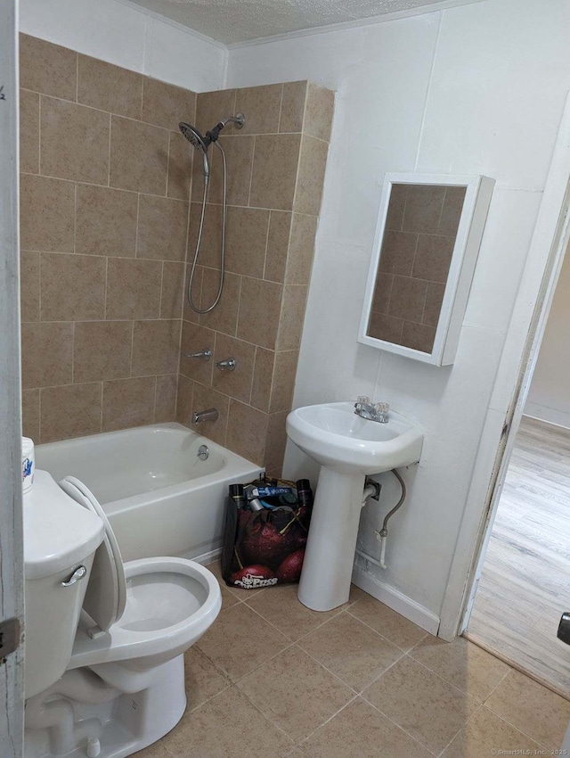 bathroom featuring toilet, baseboards, bathing tub / shower combination, and tile patterned floors