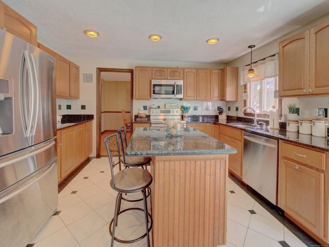 kitchen featuring a kitchen island, stainless steel appliances, a kitchen breakfast bar, and light brown cabinets