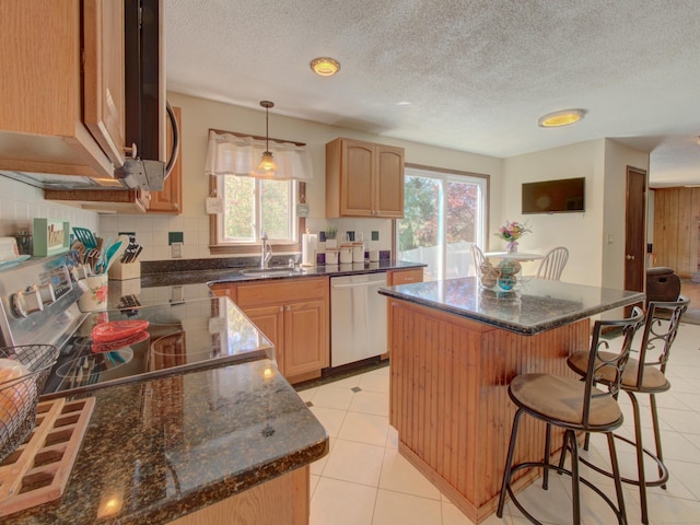 kitchen featuring a sink, a kitchen breakfast bar, stainless steel appliances, backsplash, and a kitchen island