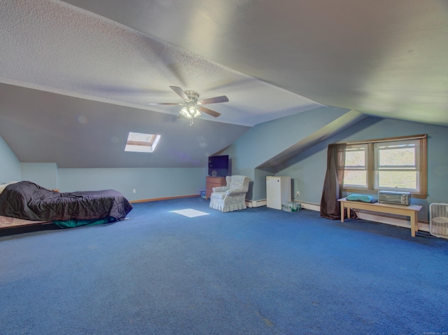 carpeted bedroom with a ceiling fan, baseboards, vaulted ceiling with skylight, and a textured ceiling