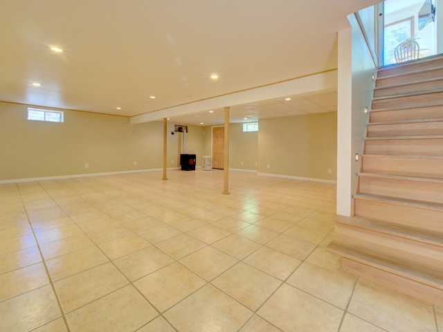 basement with recessed lighting, stairs, light tile patterned floors, and a wealth of natural light