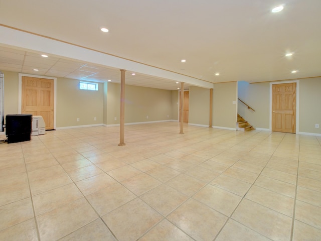 below grade area with light tile patterned floors, recessed lighting, and stairs
