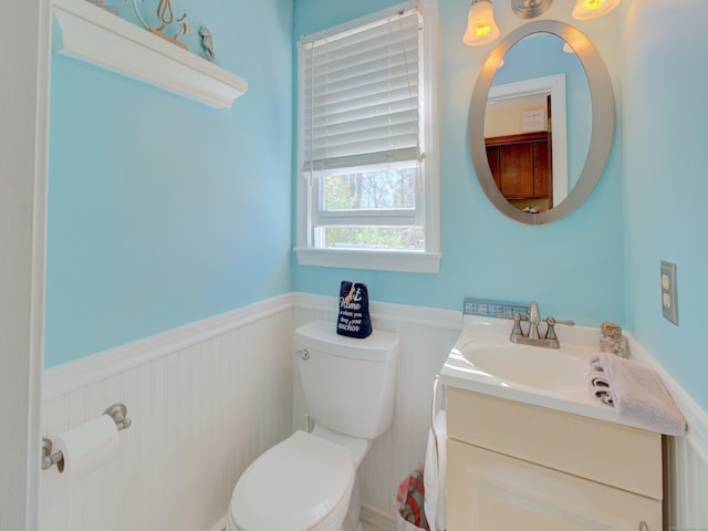 bathroom featuring a wainscoted wall, vanity, and toilet