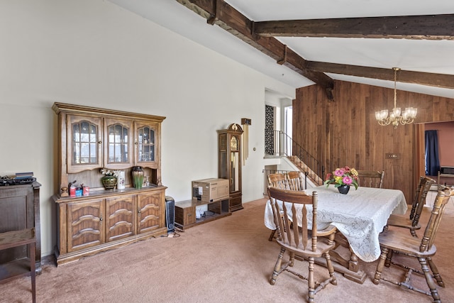 dining space with carpet flooring, an inviting chandelier, lofted ceiling with beams, and stairs