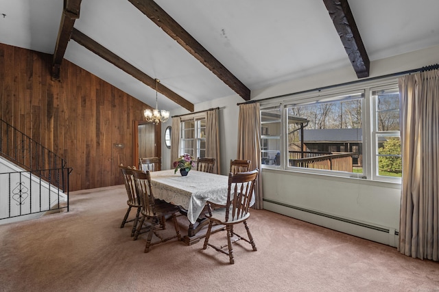 carpeted dining space with wood walls, stairway, lofted ceiling with beams, a baseboard heating unit, and an inviting chandelier
