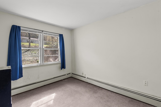 spare room with a baseboard heating unit and carpet
