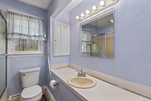 bathroom featuring vanity, a shower with door, a baseboard heating unit, and toilet