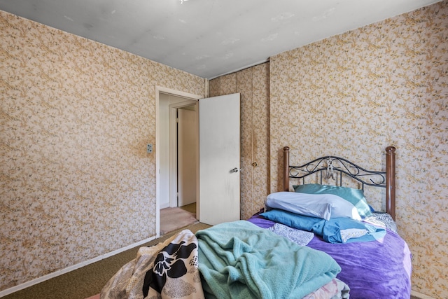 bedroom featuring baseboards, carpet flooring, and wallpapered walls