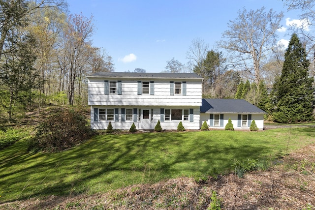 colonial-style house featuring a front lawn