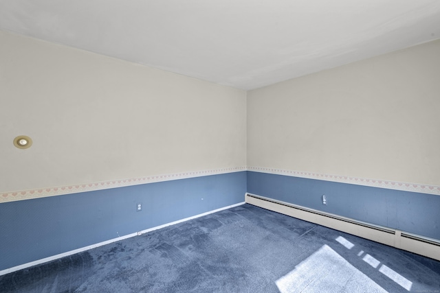 unfurnished room featuring baseboards, a baseboard heating unit, and dark carpet