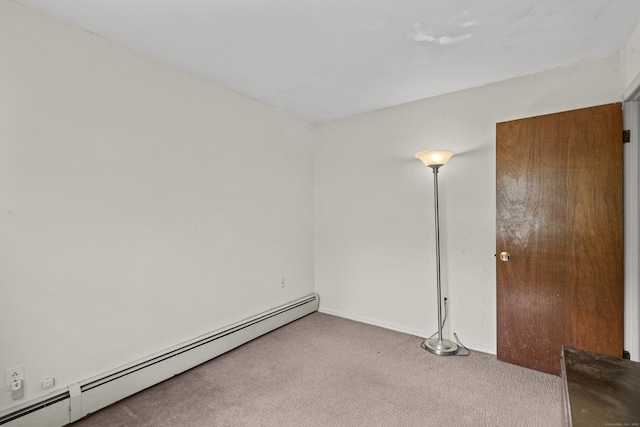 carpeted empty room with baseboards and a baseboard radiator