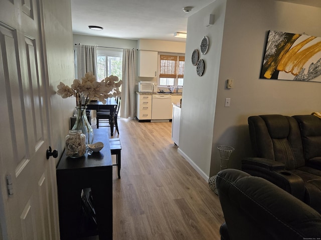 corridor featuring baseboards and light wood-type flooring