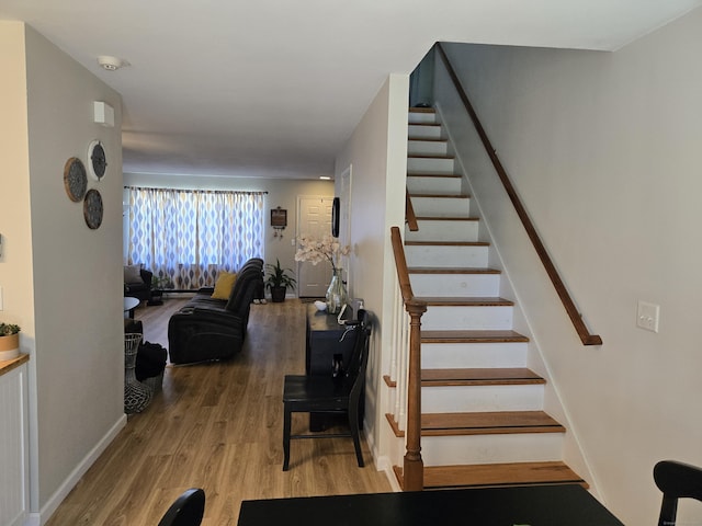 staircase with baseboards and wood finished floors