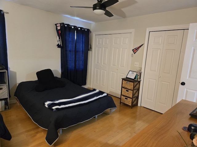 bedroom with ceiling fan, multiple closets, and light wood-type flooring