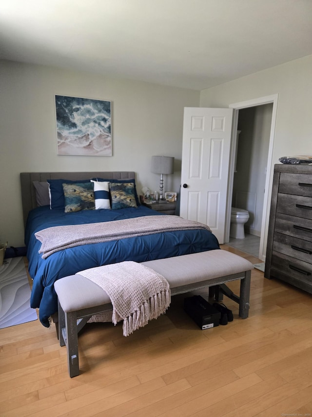 bedroom featuring connected bathroom and light wood finished floors