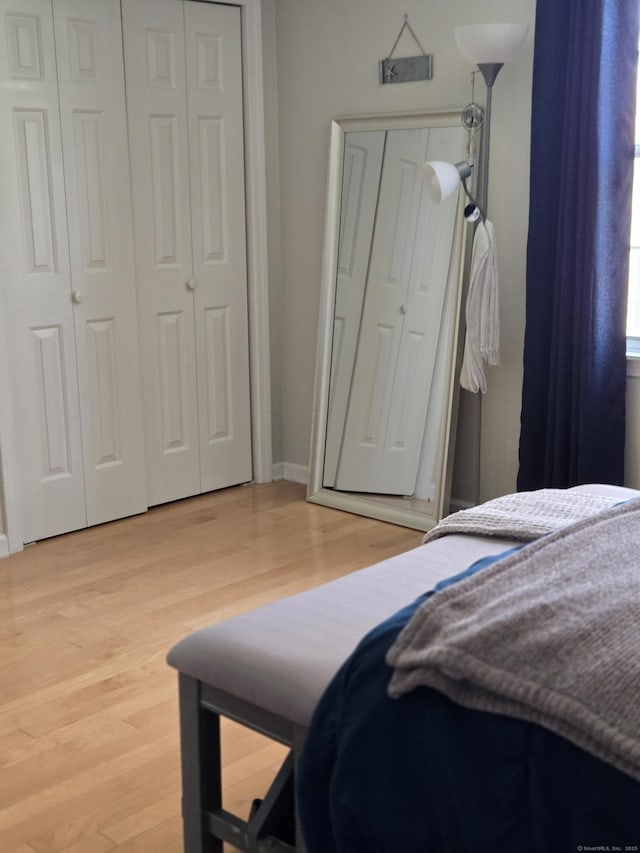bedroom with baseboards and light wood-style flooring