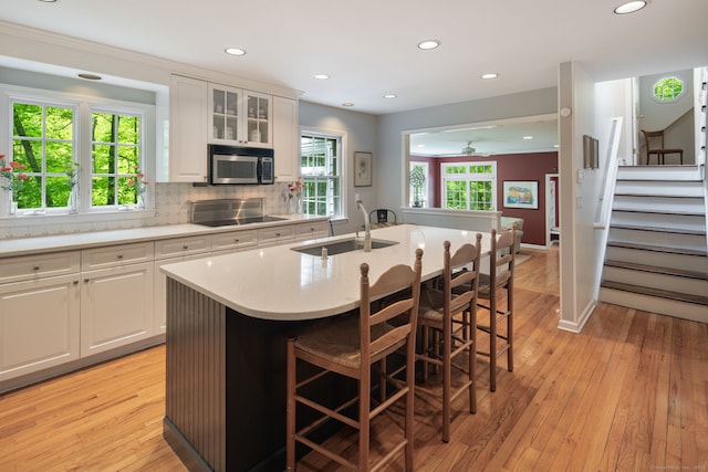 5 Dorr Rd, Darien, CT 06820 - kitchen with a sink, stainless steel microwave, black electric stovetop, white cabinetry, and recessed lighting