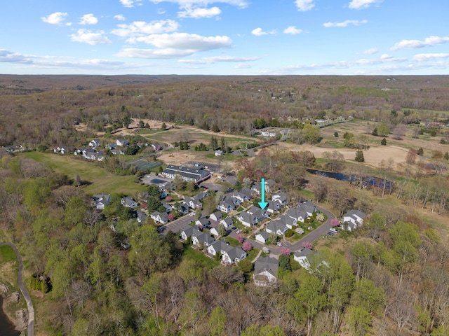 drone / aerial view featuring a residential view and a wooded view