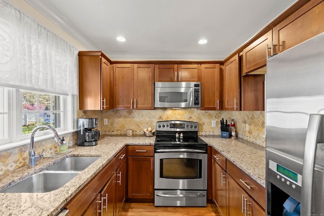 kitchen featuring brown cabinetry, a sink, decorative backsplash, and stainless steel appliances