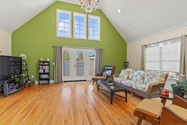 living area featuring french doors, high vaulted ceiling, a chandelier, and wood finished floors