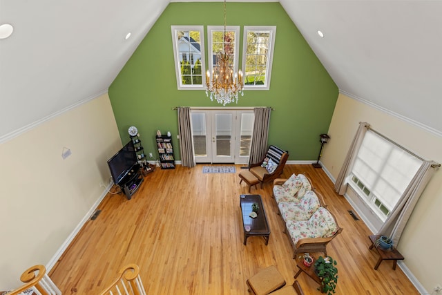 interior space featuring french doors, wood finished floors, baseboards, a notable chandelier, and lofted ceiling