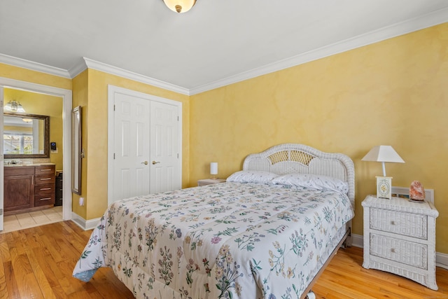 bedroom with baseboards, a closet, connected bathroom, light wood-style floors, and ornamental molding
