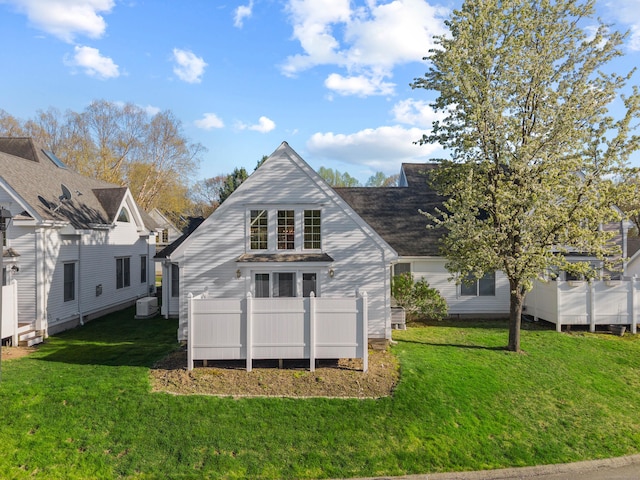 back of property featuring a yard and central AC