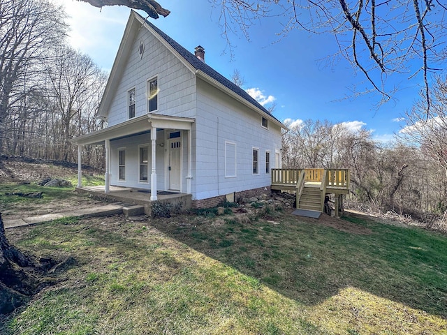 39 Tanner Ave, Norwich, CT 06360 - view of side of property featuring a chimney, covered porch, a yard, and stairs