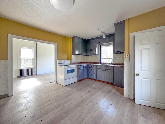 39 Tanner Ave, Norwich, CT 06360 - kitchen with white electric stove, radiator heating unit, light wood finished floors, and gray cabinets