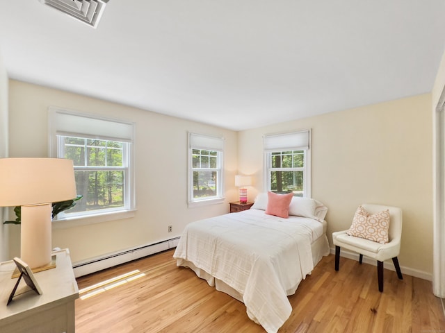 34 Longmeadows Rd, Wilton, CT 06897 - bedroom with multiple windows, a baseboard heating unit, light wood finished floors, and visible vents