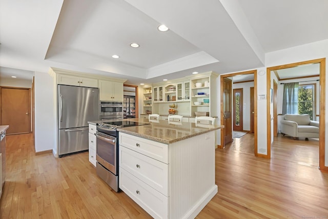 4 Walnut Ridge Rd, New Fairfield, CT 06812 - kitchen with open shelves, light wood finished floors, stainless steel appliances, a kitchen island, and a tray ceiling