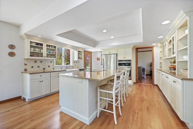 4 Walnut Ridge Rd, New Fairfield, CT 06812 - kitchen featuring appliances with stainless steel finishes, a sink, a raised ceiling, light wood-style floors, and a center island