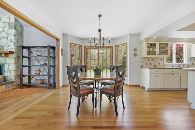 4 Walnut Ridge Rd, New Fairfield, CT 06812 - dining space featuring an inviting chandelier, baseboards, a fireplace, and light wood-type flooring